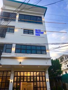 a white building with a sign on it at Blue Waters Inn Coron Palawan in Coron