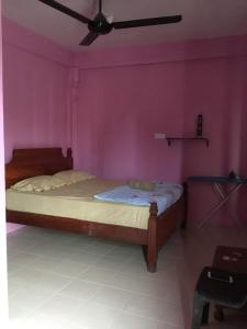 a bedroom with a bed with a pink wall at Standard Room (Pakej G1) in Semporna