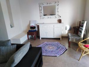 sala de estar con sofá, sillas y espejo en Habitaciones en Casa compartida Retamar, en Almería