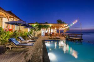 a villa with a swimming pool at night at Nusa Veranda Sunset Villas & Restaurant in Nusa Lembongan