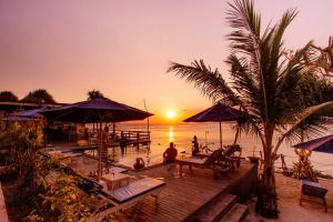 a beach with palm trees and palm trees at Nusa Veranda Sunset Villas & Restaurant in Nusa Lembongan