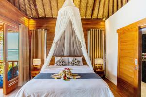 a bed room with a bed and a table at Nusa Veranda Sunset Villas & Restaurant in Nusa Lembongan