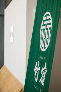 a green and white sign next to a table at Hostel Takeyado in Osaka