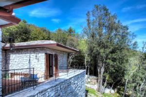 Casa Vacanze Assisi في سبيلّو: منزل حجري صغير مع شرفة