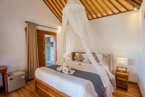 a bedroom with a bed, a dresser, and a window at Nusa Veranda Sunset Villas & Restaurant in Nusa Lembongan