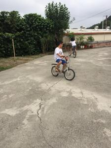 dos niños montando bicicletas en un estacionamiento en Chulu ecological farm B&B, en Chulu