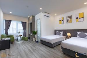 um quarto de hotel com duas camas e uma televisão em Nha Trang Moony Hotel em Nha Trang