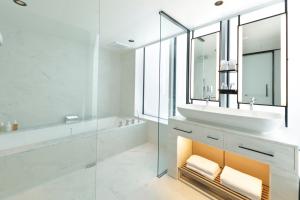 a bathroom with a sink and a tub and a mirror at Hamacho Hotel Tokyo in Tokyo