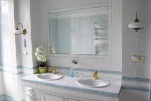 ein Badezimmer mit 2 Waschbecken und einem Spiegel in der Unterkunft Taverna panzió in Sopron
