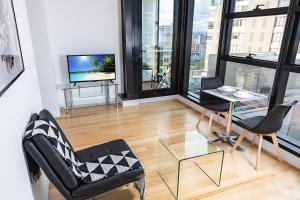 a living room with a table and chairs and a television at Executive stay Little Collins street in Melbourne