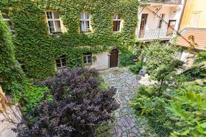 un bâtiment recouvert de lierre avec un jardin en face de celui-ci dans l'établissement Apartment Nebovidy I - Free Parking - Terrace - Air Conditioning, à Prague