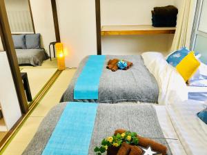 a room with two beds with a teddy bear on the middle at 板橋 RCアネックス Rc208 in Tokyo