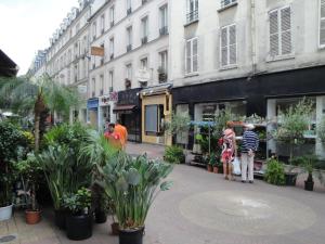 un gruppo di persone che camminano per una strada con delle piante di Almeria Garden Apartment a Parigi