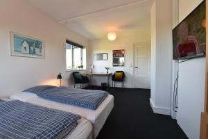 een hotelkamer met 2 bedden en een bureau bij Maybom Kolding - Bed & Breakfast in Kolding