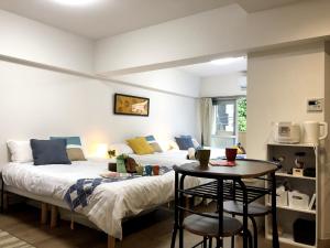 sypialnia z 2 łóżkami i małym stołem w obiekcie 板橋 RCアネックス Rc207 w Tokio