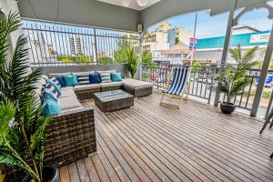 a patio with a couch and chairs on a balcony at The Village Cairns in Cairns