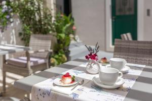 a table with two cups and a cake on it at Balatura The Fine Bed&Breakfast Split in Split
