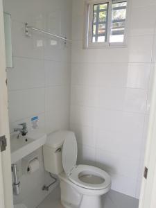 een witte badkamer met een toilet en een wastafel bij Seascape Beach Resort Oslob in Oslob