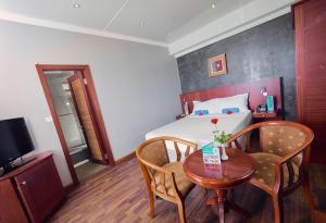 una camera d'albergo con tavolo e letto di Gold Beach Resort a Flic-en-Flac