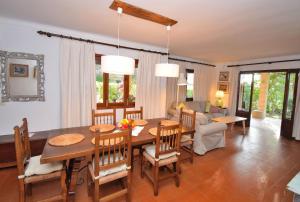 comedor y sala de estar con mesa y sillas en Casa Trevol 020 by Mallorca Charme en Alcudia