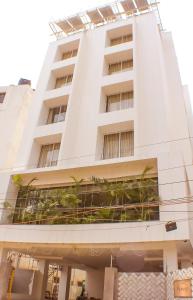 um edifício branco com plantas na lateral em The Pioneer em Visakhapatnam