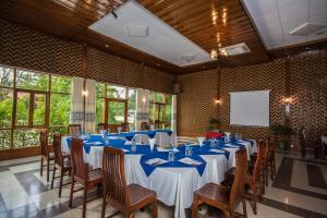 uma sala de conferências com mesas e cadeiras e um ecrã em Ruby True Hotel em Bagan