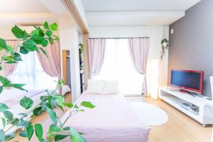 a living room with a bed and a tv at Miraie Osaka Higashinari202 in Osaka