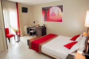 sypialnia z dużym łóżkiem i biurkiem w obiekcie Le Grand Mellis Hôtel & Spa w Antananarywie
