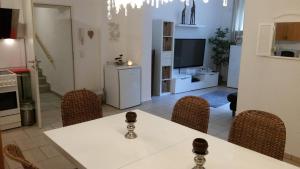 Il comprend une cuisine et une salle à manger avec une table et des chaises blanches. dans l'établissement Ferienwohnung auf dem Land Schermbeck Moviepark, à Schermbeck