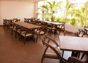 a dining room with tables and chairs and a large window at The Pioneer in Visakhapatnam