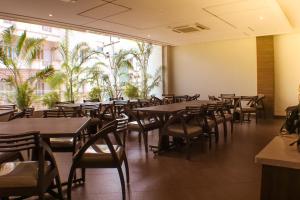 un restaurante con mesas y sillas y una gran ventana en The Pioneer, en Visakhapatnam