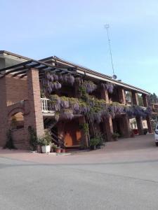 a building with purple flowers on the side of it at Agriturismo Doremi in Vignolo