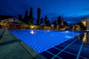 uma piscina à noite com iluminação azul em Ruby True Hotel em Bagan