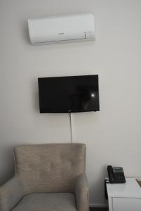 a room with a couch and a television on a wall at Rimon Cyprus Israeli Kosher Rooms in Larnaca