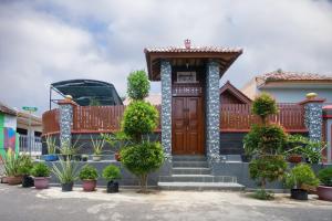 a house with a wooden door and a porch at Maharani Homestay in Banyuwangi