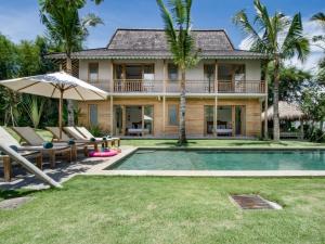 a villa with a swimming pool and a house at Villa Alea in Kerobokan