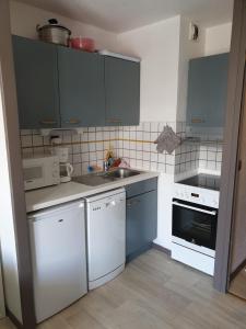 - une petite cuisine avec des appareils blancs et des armoires bleues dans l'établissement MEIJE 3, à Les Deux Alpes