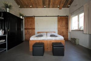 a bedroom with a bed and two chairs in it at Studio Rent Jamzes in Hoogerheide