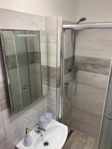 y baño con lavabo y ducha con espejo. en Mikulov - Inn - hotel s vinným sklepem Venuše, en Mikulov