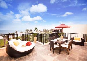 
a patio area with a patio table and chairs at JA Palm Tree Court (JA The Resort) in Dubai
