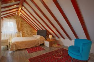 a bedroom with a bed and a blue chair at Apartments Kaleta in Split