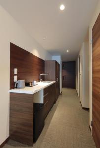 a kitchen with wooden cabinets and a counter top at HOTEL PROMOTE HIROSHIMA in Hiroshima