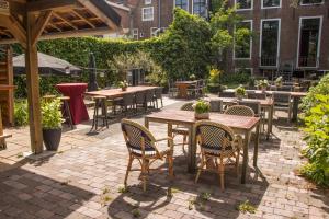 een patio met tafels en stoelen op een binnenplaats bij Hotel aan de Dam in Middelburg