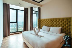 Dwa łabędzie siedzą na łóżku w pokoju hotelowym w obiekcie Expressionz Professional Suites by MyKey Global w Kuala Lumpur