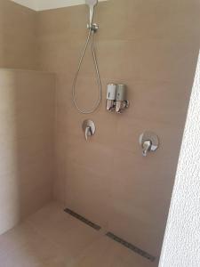 a shower with two shower heads on a wall at Casinha Vista Mar in Porto Santo