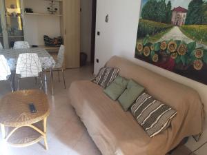 un soggiorno con divano e un dipinto sul muro di Villetta indipendente presso Villaggio Demetra Policoro a Policoro