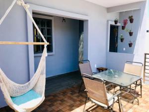 a porch with a hammock and a table and chairs at CASA MALIX Puerto Morelos in Puerto Morelos