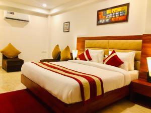 een slaapkamer met een groot bed met rode en gele kussens bij Red Crown Hotel in New Delhi