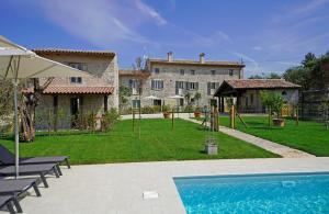 uma casa com um quintal com uma piscina e um parque infantil em Dogoli Country Apartments em Bardolino