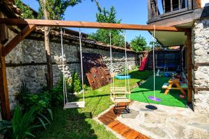 un patio con un columpio y un parque infantil en Banskovilla Zlateva House, en Bansko